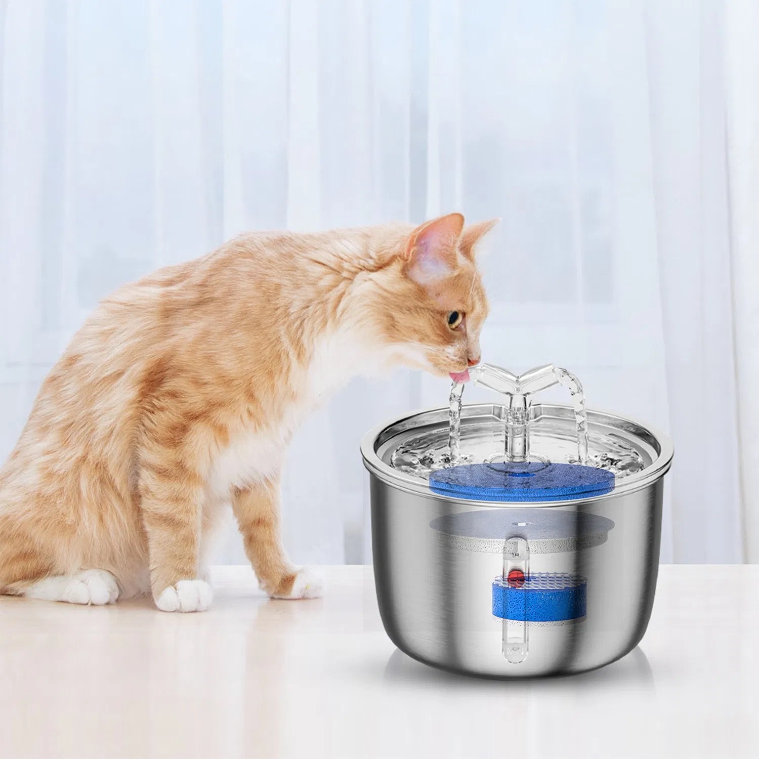 An orange cat drinking from the quiet stainless fountain